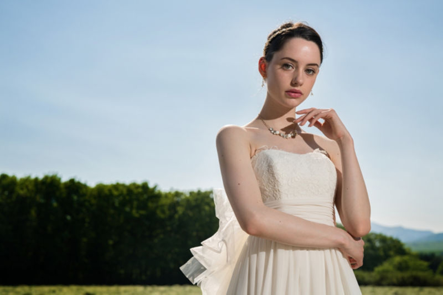 Imagen de ejemplo de una mujer usando un vestido blanco con un bosque de fondo