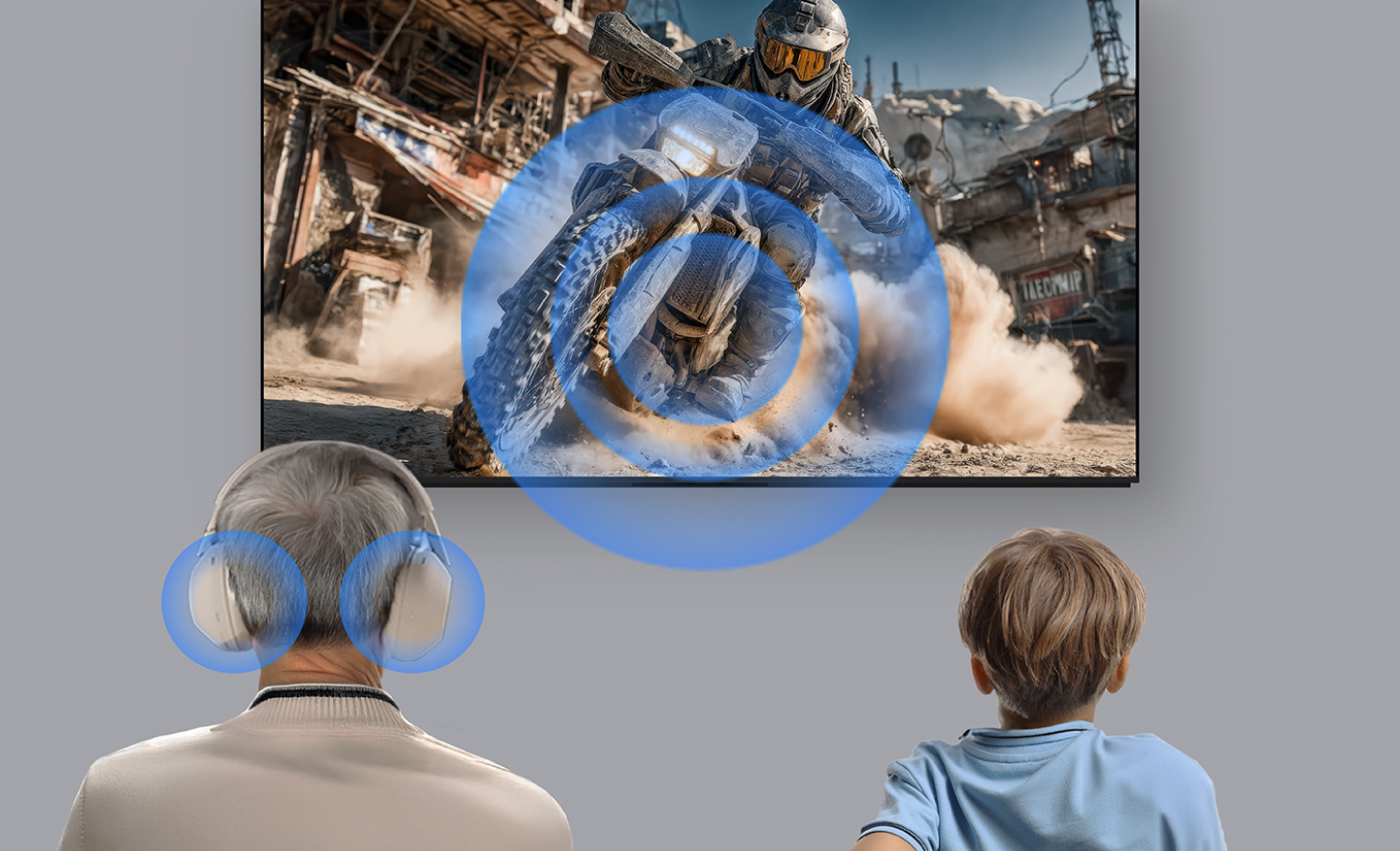 Un adulto mayor con audífonos puestos y un niño sentado a su lado ven una escena de acción en la pantalla de un televisor. Las ondas de sonido azules irradian desde la pantalla hacia el oyente, lo que ilustra la reproducción de audio compartida o simultánea, de modo que ambos espectadores experimentan el mismo sonido del contenido.